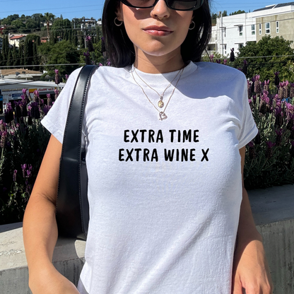 White fitted baby tee with black “Extra Time Extra Wine X” slogan, styled casually with a shoulder bag, perfect for football match days and wine lovers