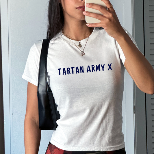 White fitted baby tee with navy “Tartan Army X” slogan, styled casually with a shoulder bag, perfect for Scotland football fans and match day outfits