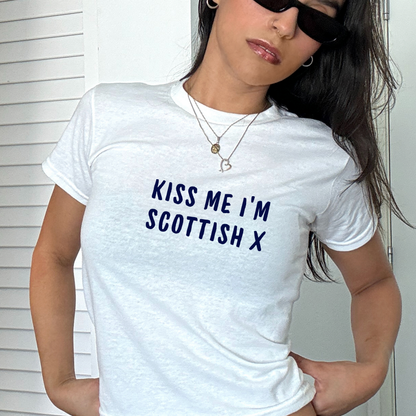 White fitted baby tee with navy “Kiss Me I’m Scottish X” slogan, styled casually with a shoulder bag, perfect for Scotland football fans and match day outfits