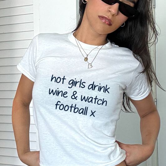 White baby tee with navy “hot girls drink wine and watch football x” slogan, funny women’s football fan shirt